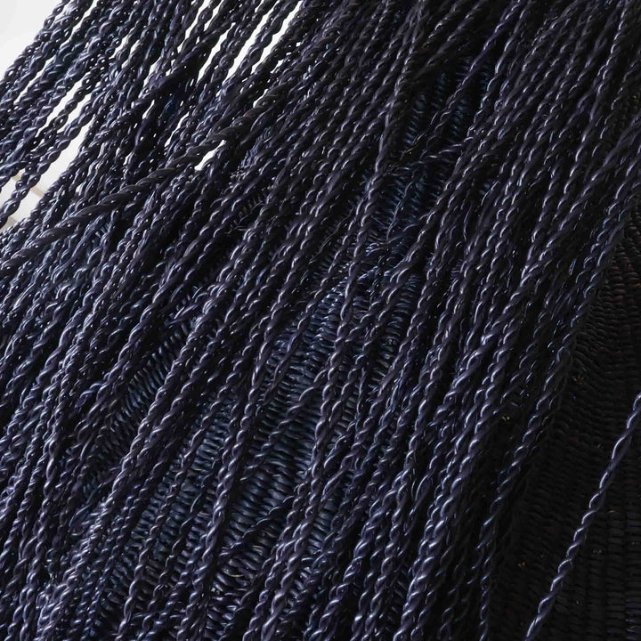 Close detail of the tight twist weave and fringe on the hairy black wavy basket
