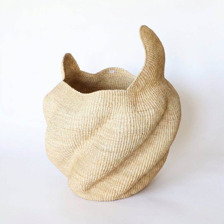 Open top natural wavy sculptural basket with sweeping horn-like peaks, on white