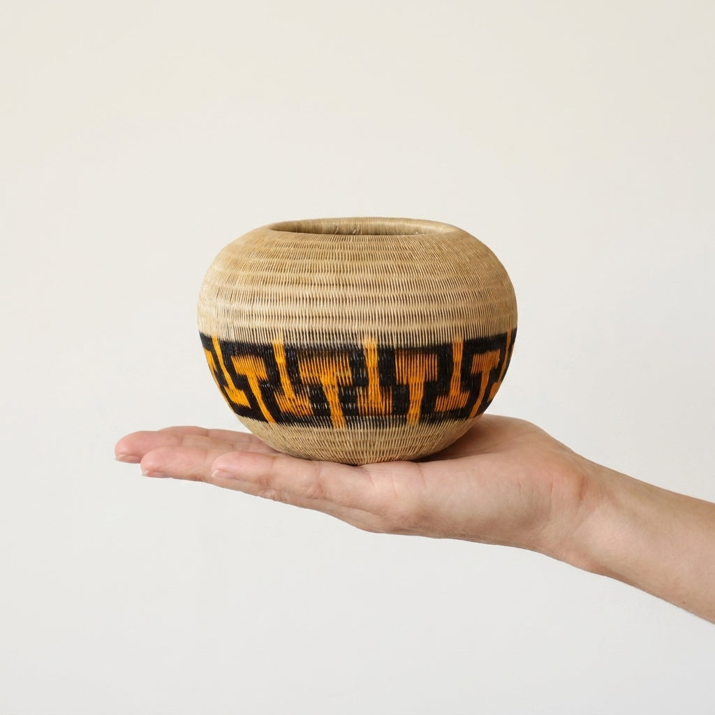 Amber Key Basket, one of one werregue basket handwoven by Wounaan weavers in Chocó, Colombia, held in hand for scale