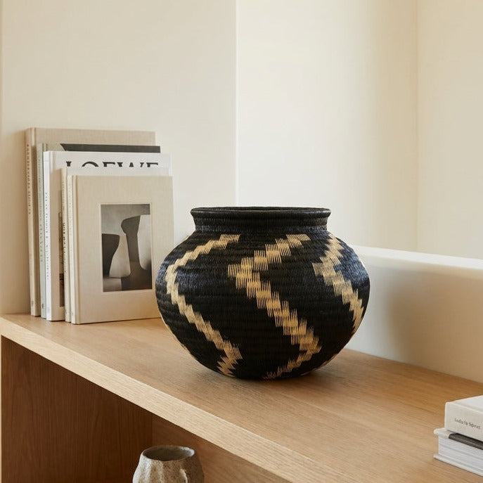 Ivory Cascade Jar, one of one werregue basket handwoven by Wounaan weavers in Chocó, Colombia, styled on a shelf