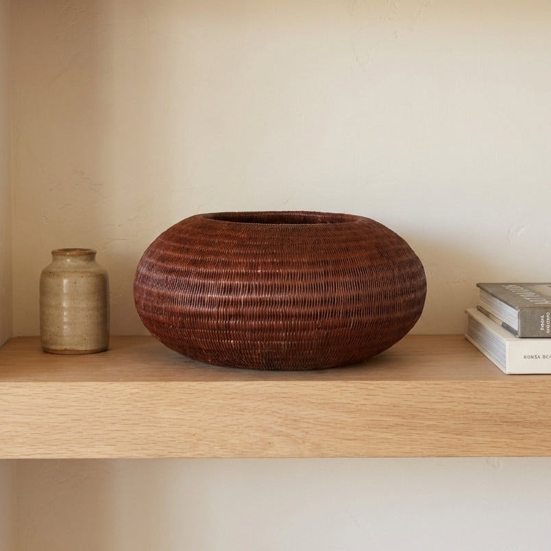 Russet Nest Vessel, one of one werregue basket handwoven by Wounaan weavers in Chocó, Colombia, styled on a shelf