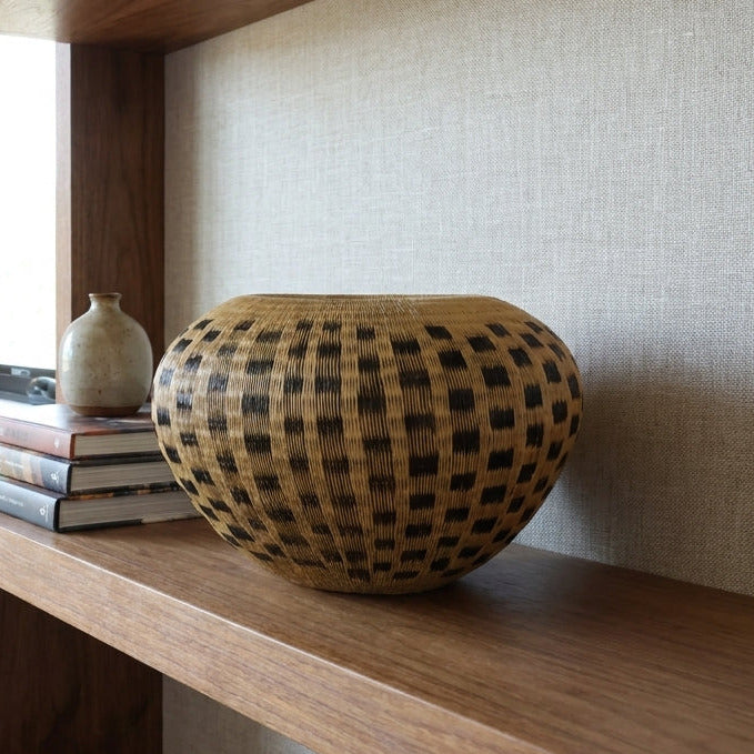 Pebble Field Basket, one of one werregue basket handwoven by Wounaan weavers in Chocó, Colombia, styled on a shelf