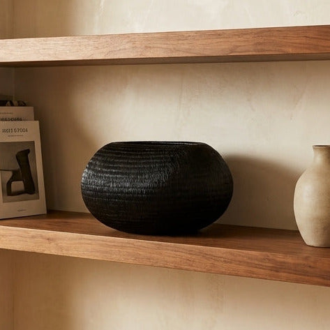Obsidian Curve Vessel, one of one werregue basket handwoven by Wounaan weavers in Chocó, Colombia, styled on a shelf
