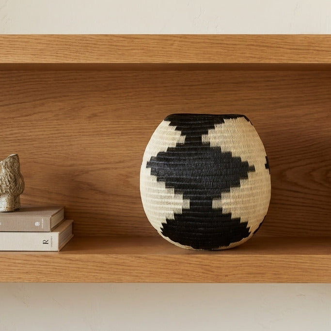 Bold Diamonds Vessel, one of one werregue basket handwoven by Wounaan weavers in Chocó, Colombia, styled on a shelf