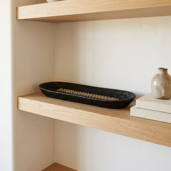 Golden Ribbon Platter, one of one werregue basket handwoven by Wounaan weavers in Chocó, Colombia, styled on a shelf