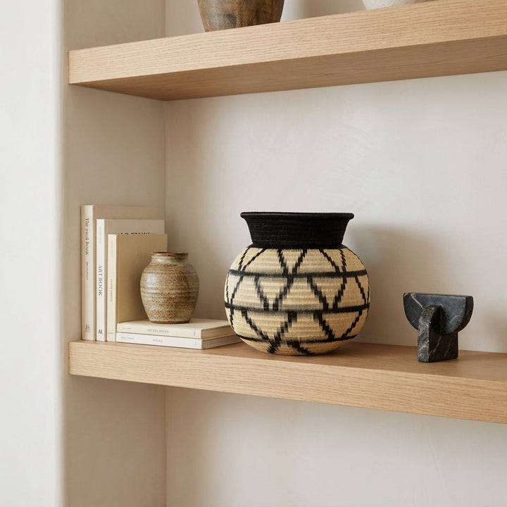 Peak Lattice Jar, one of one werregue basket handwoven by Wounaan weavers in Chocó, Colombia, styled on a shelf