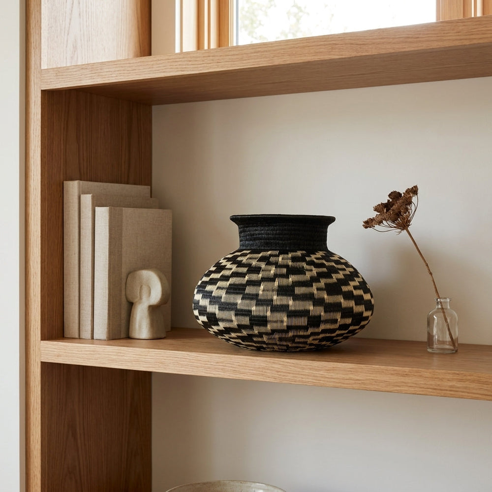 Scattered Steps Jar, one of one werregue basket handwoven by Wounaan weavers in Chocó, Colombia, styled on a shelf