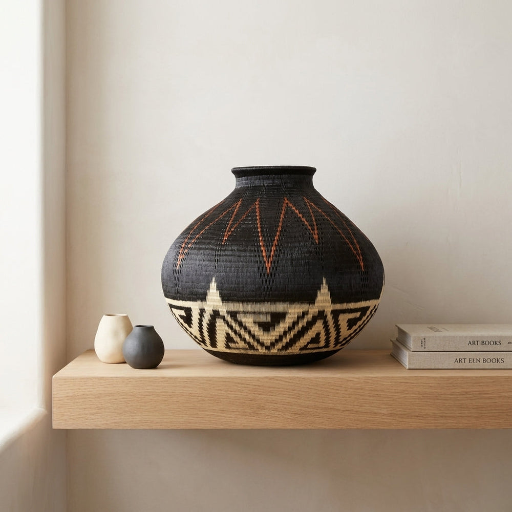 Storm Over Mountains, one of one werregue basket handwoven by Wounaan weavers in Chocó, Colombia, styled on a shelf