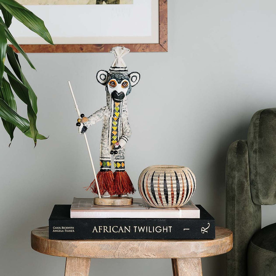 image: Small sculptural basket displayed on console in modern interior setting