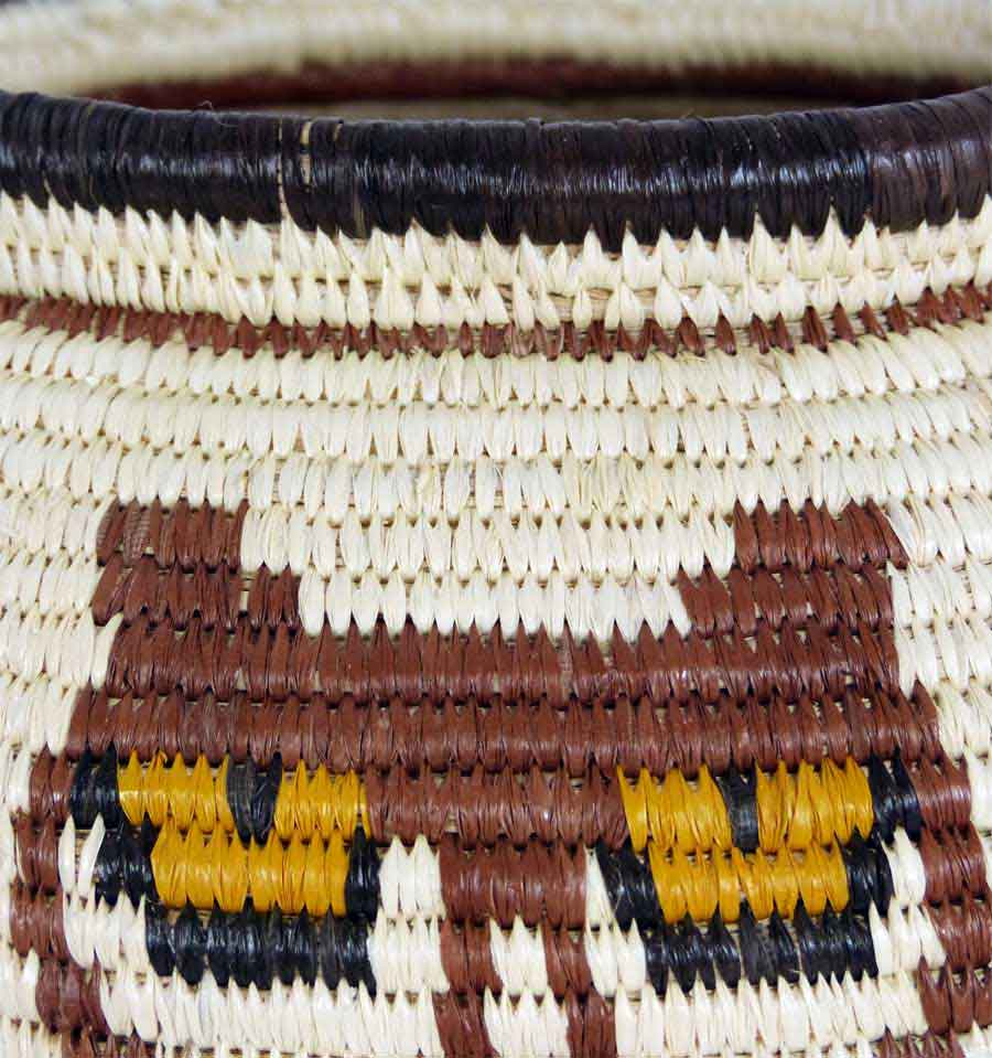 Close-up detail of yellow owl eyes pattern in traditional Wounaan coil weaving technique with natural dyes