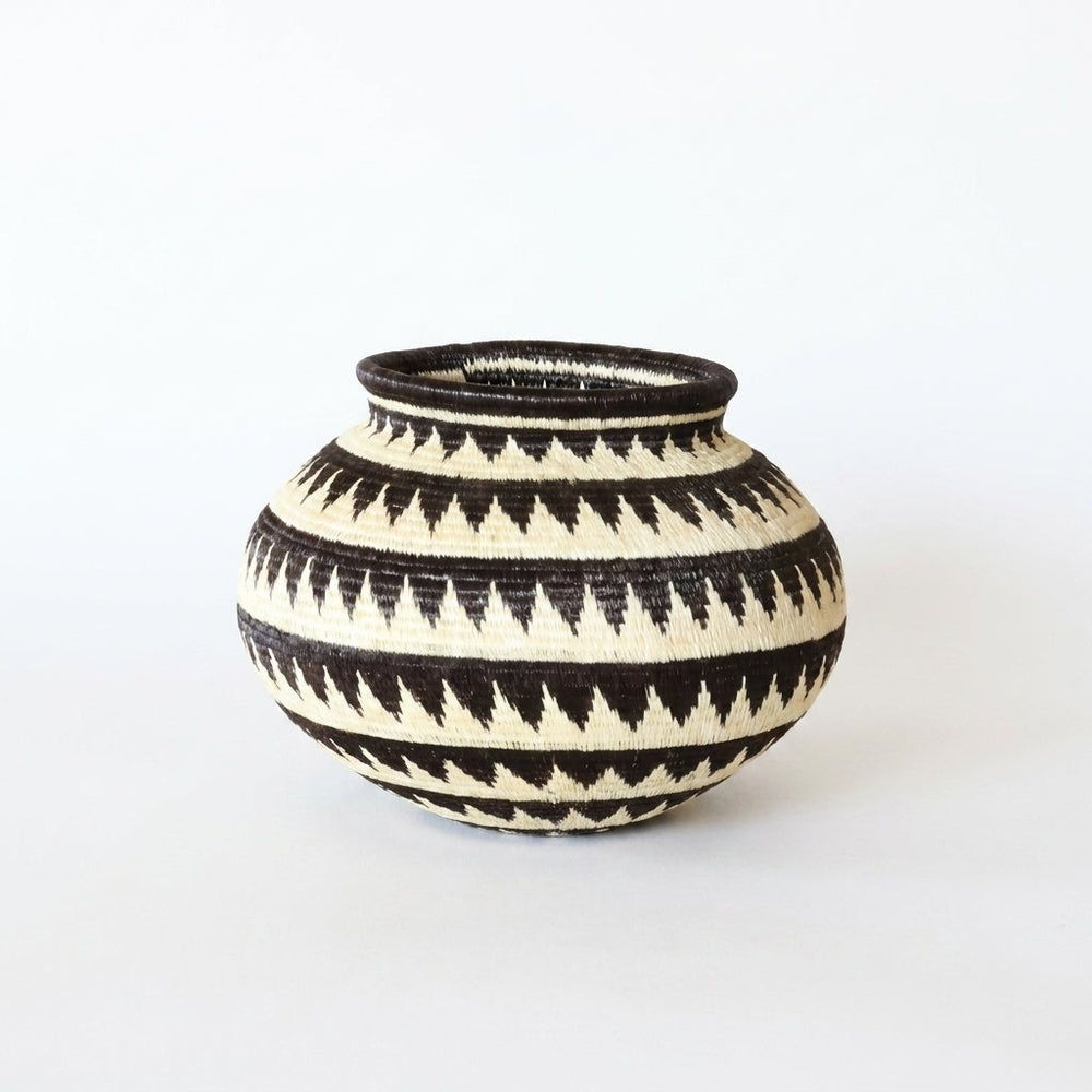 Handwoven Wounaan basket with black and cream sawtooth triangle bands, rounded vase form from Darién, Panama