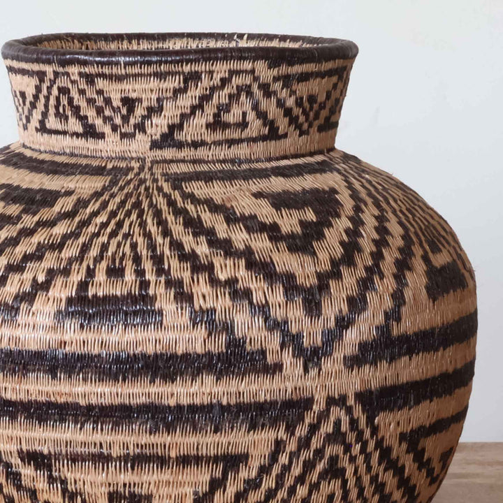 Close-up detail of intricate Triad Path weaving pattern showing tight palm fiber coil construction technique
