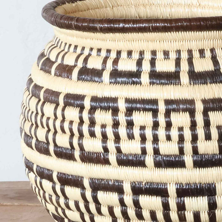 Close-up of tight coiled weave and geometric labyrinth design in Wounaan palm fiber basket