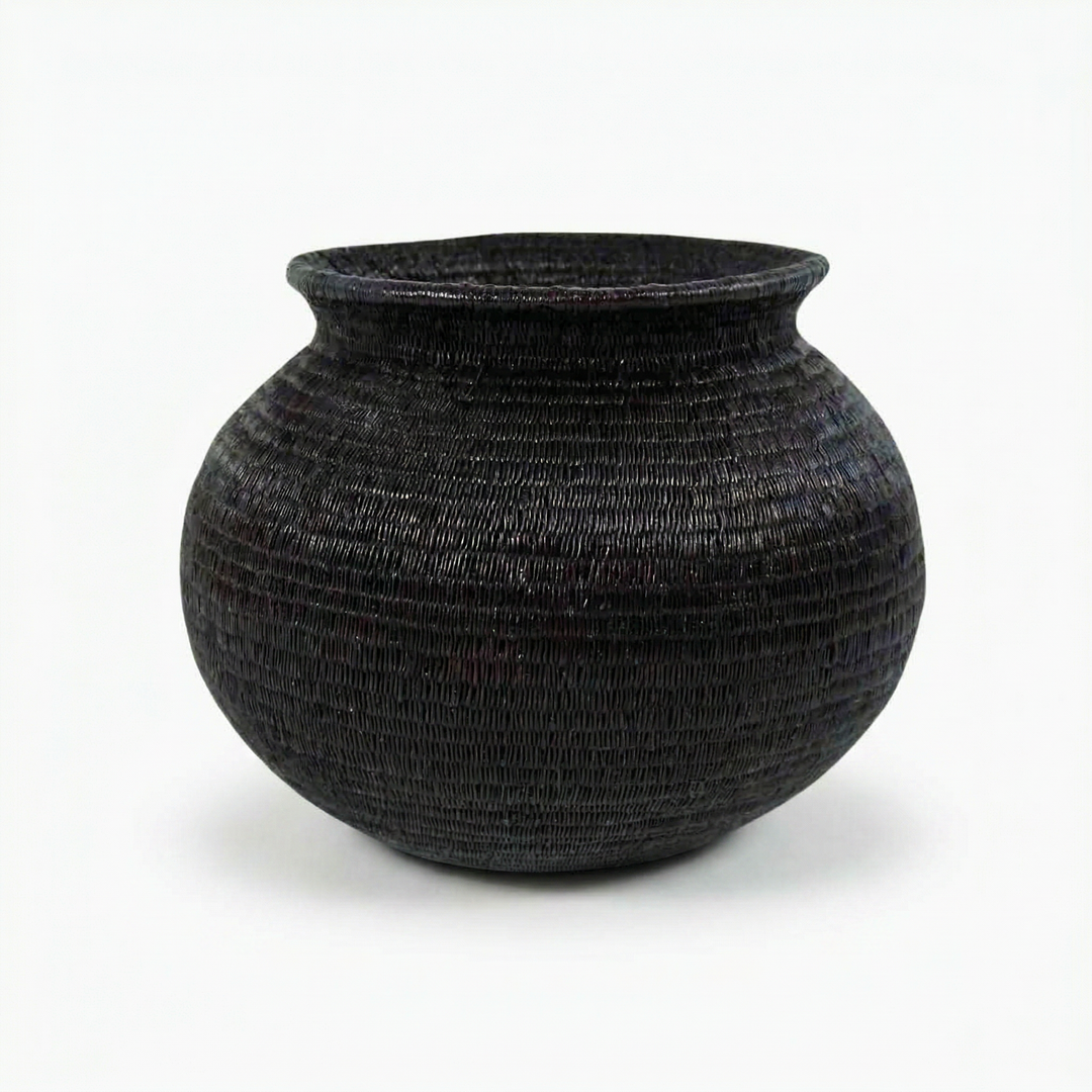 Close view of all-black Wounaan basket showing fine coil-weave texture in jagua-dyed werregue palm fiber