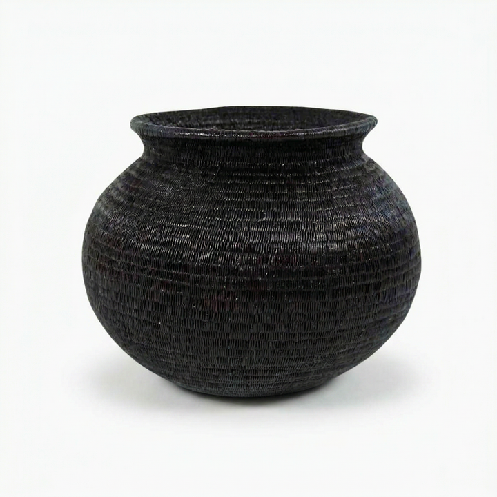 Close view of all-black Wounaan basket showing fine coil-weave texture in jagua-dyed werregue palm fiber