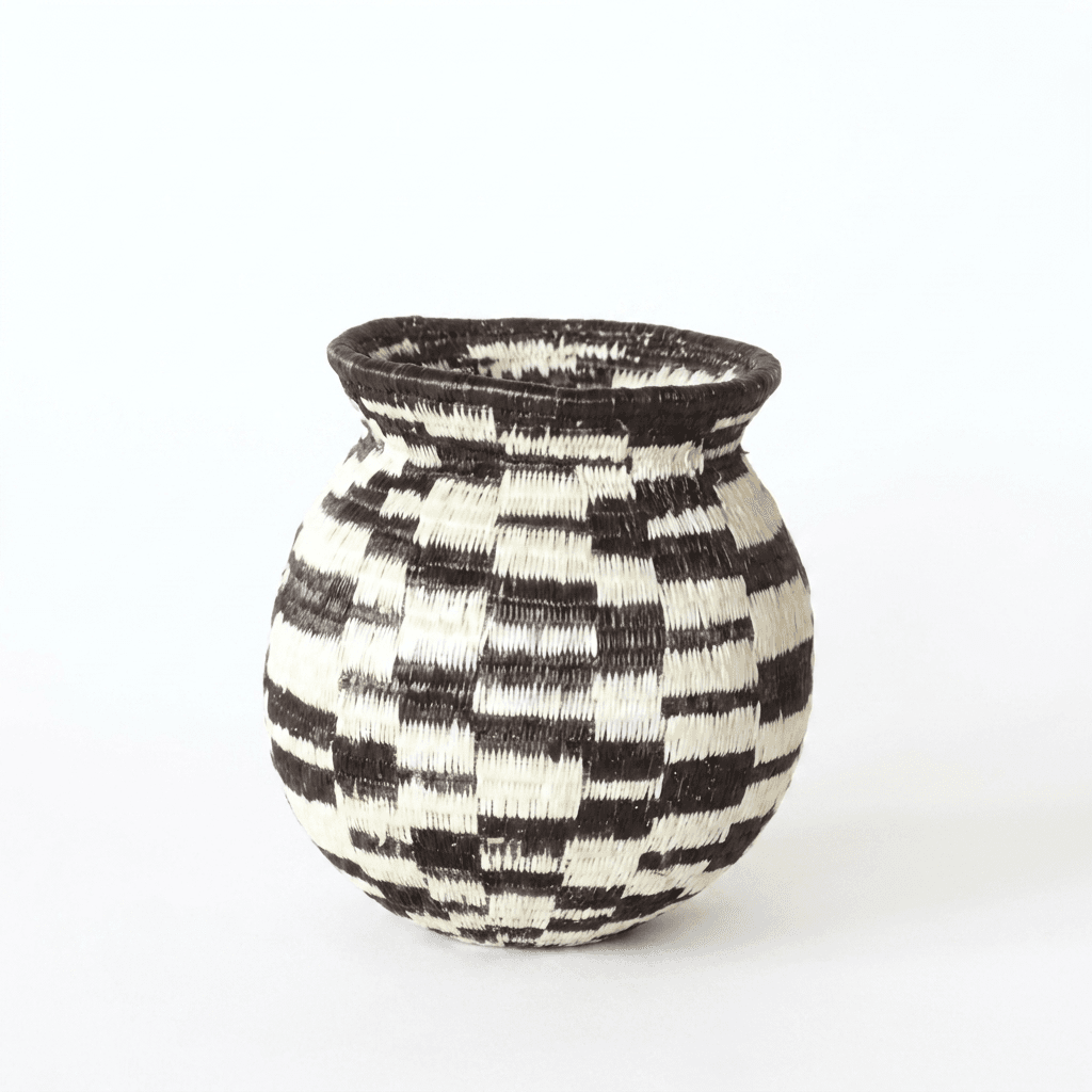 Tiny handwoven Wounaan basket with staggered black and white checkerboard blocks and dark rim, from Panama