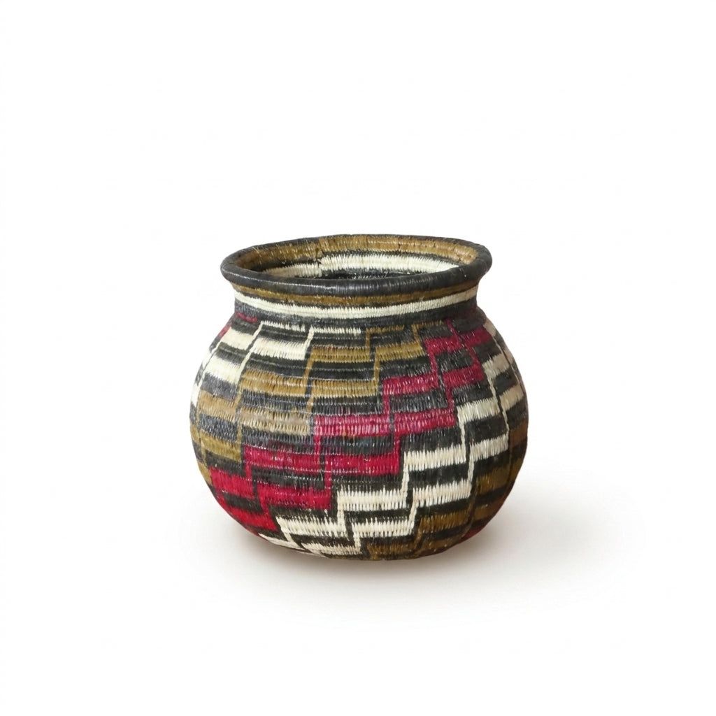 Mini Wounaan basket showing interlocking red, brown, black and white stair-step motif in woven palm fiber