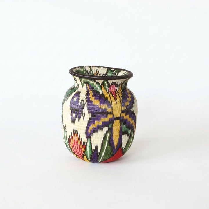 Wounaan basket reverse side showing purple and gold butterfly with red flowers and green leaves in woven palm