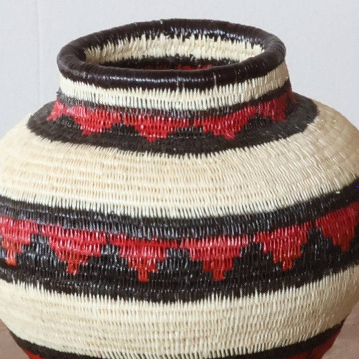 Close-up werregue palm weaving showing crimson crest pattern and natural dye craftsmanship