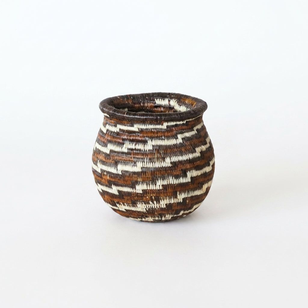 Tiny handwoven Wounaan basket with stepped swirl in espresso brown, rust and cream, flared rim, from Panama