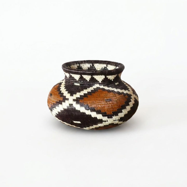 Tiny handwoven Wounaan basket with rust, black and cream stepped diamond pattern from Panama's Darién rainforest