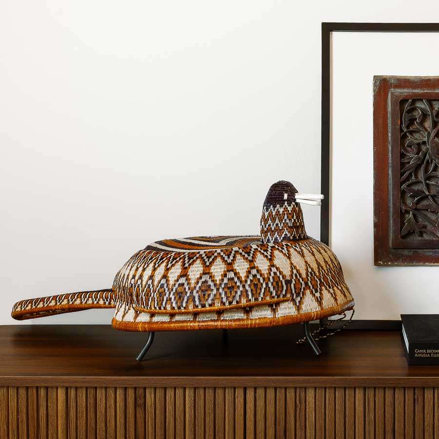 rpent-billed duck spirit mask displayed on cosole table in modern interior setting