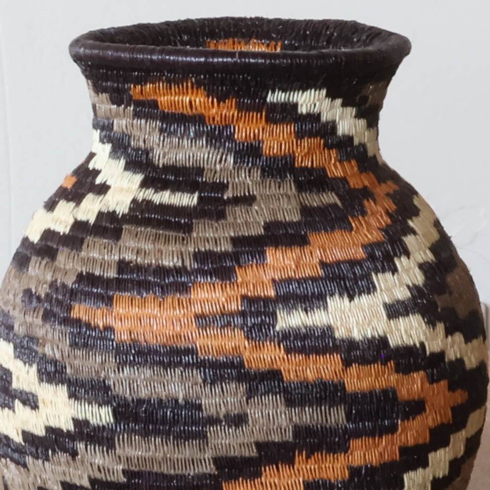 Close-up werregue palm weave showing intricate spiral pattern and natural dye techniques