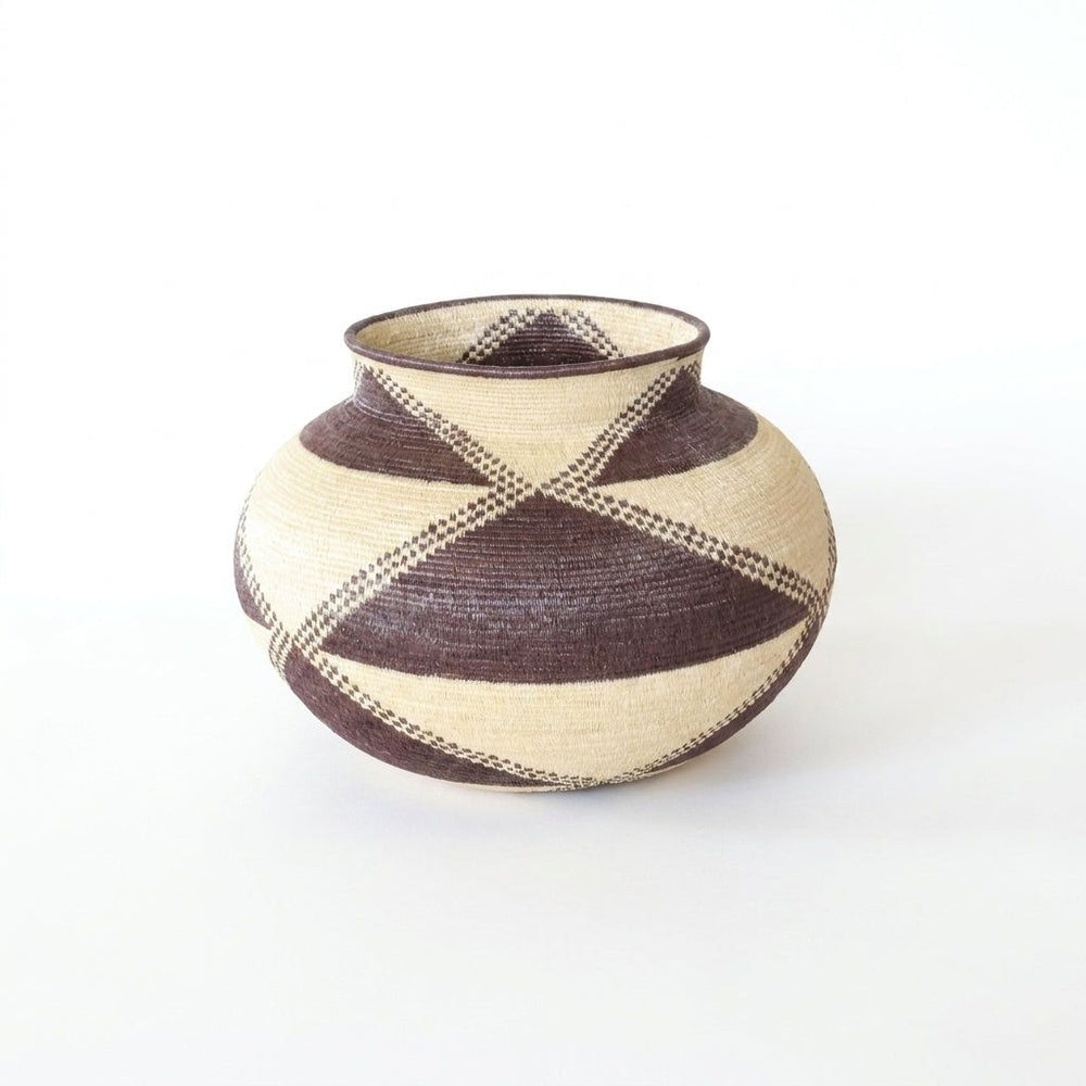 Handwoven Wounaan basket with deep brown triangles and checkered bands crossing a cream ground, Darién Panama
