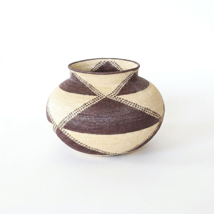Handwoven Wounaan basket with deep brown triangles and checkered bands crossing a cream ground, Darién Panama