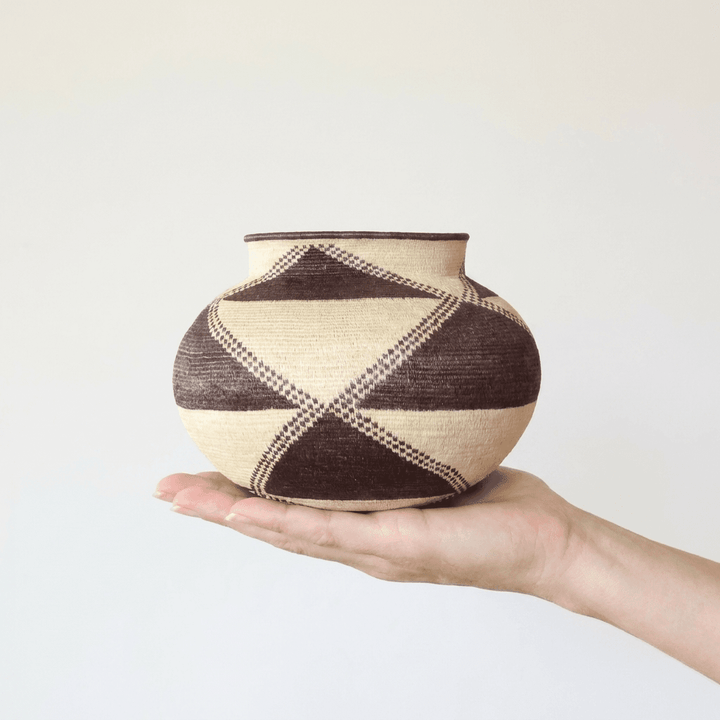 Handwoven Wounaan triangle-pattern basket held in hand showing the scale of this 7-inch Panama woven art piece