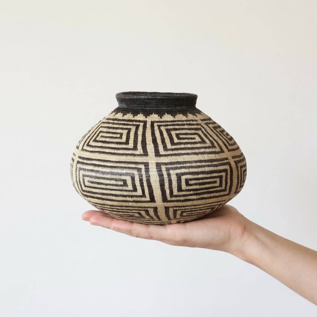 Medium sized decorative woven basket with geometric crossroads pattern in natural fibers