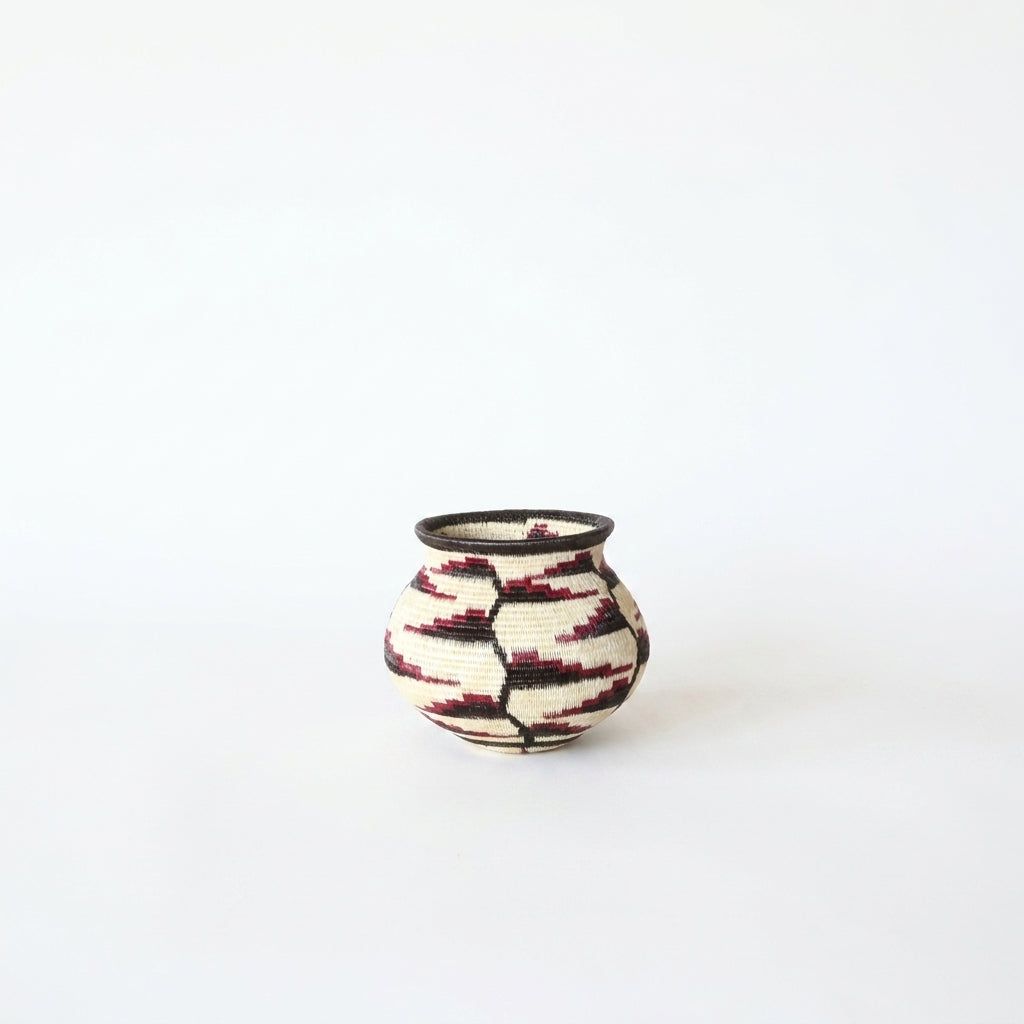 Close view of red-tipped heliconia vine motif on tiny cream Wounaan handwoven basket from Panama