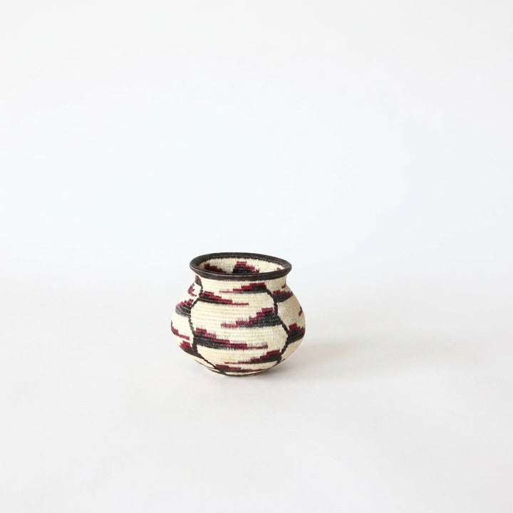 Tiny Wounaan handwoven basket with crimson and black blooms climbing a vine on cream, Panama woven art
