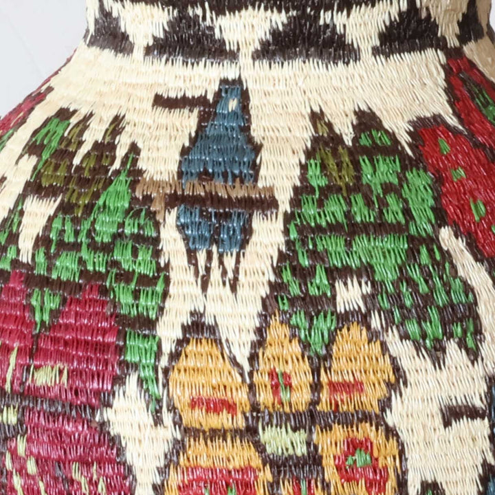 Close-up of werregue palm fiber weaving showing intricate floral motifs and natural dyes