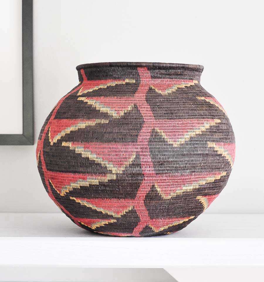 black woven basket with vibrant heliconia flower patterns by Wounaan artisans from Panama Darién