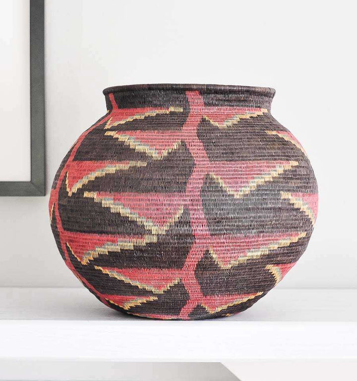 black woven basket with vibrant heliconia flower patterns by Wounaan artisans from Panama Darién