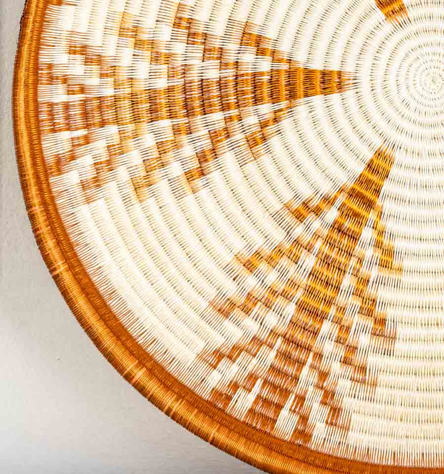Close-up detail of copper vines plate showing intricate coiled weaving technique and metallic fiber texture