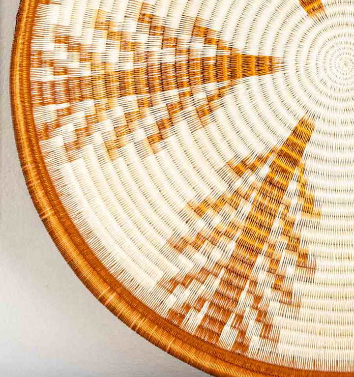 Close-up detail of copper vines plate showing intricate coiled weaving technique and metallic fiber texture