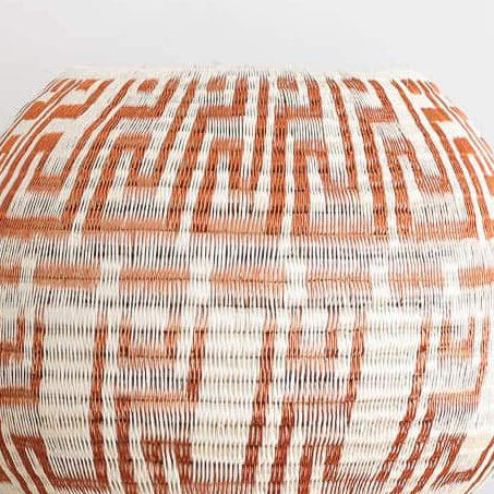 Close-up detail of copper key motif weaving pattern showing tight coil basket craftsmanship
