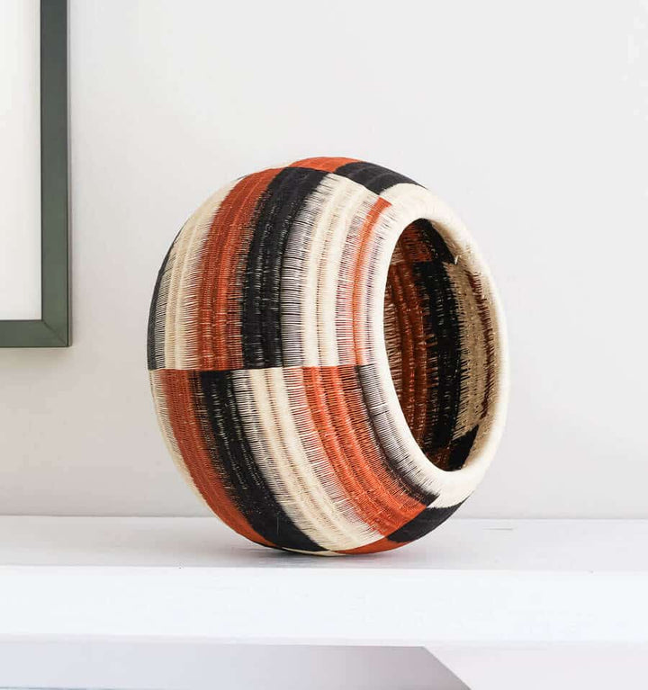 Side angle view of handmade decorative basket showing dimensional wide steps geometric weave pattern