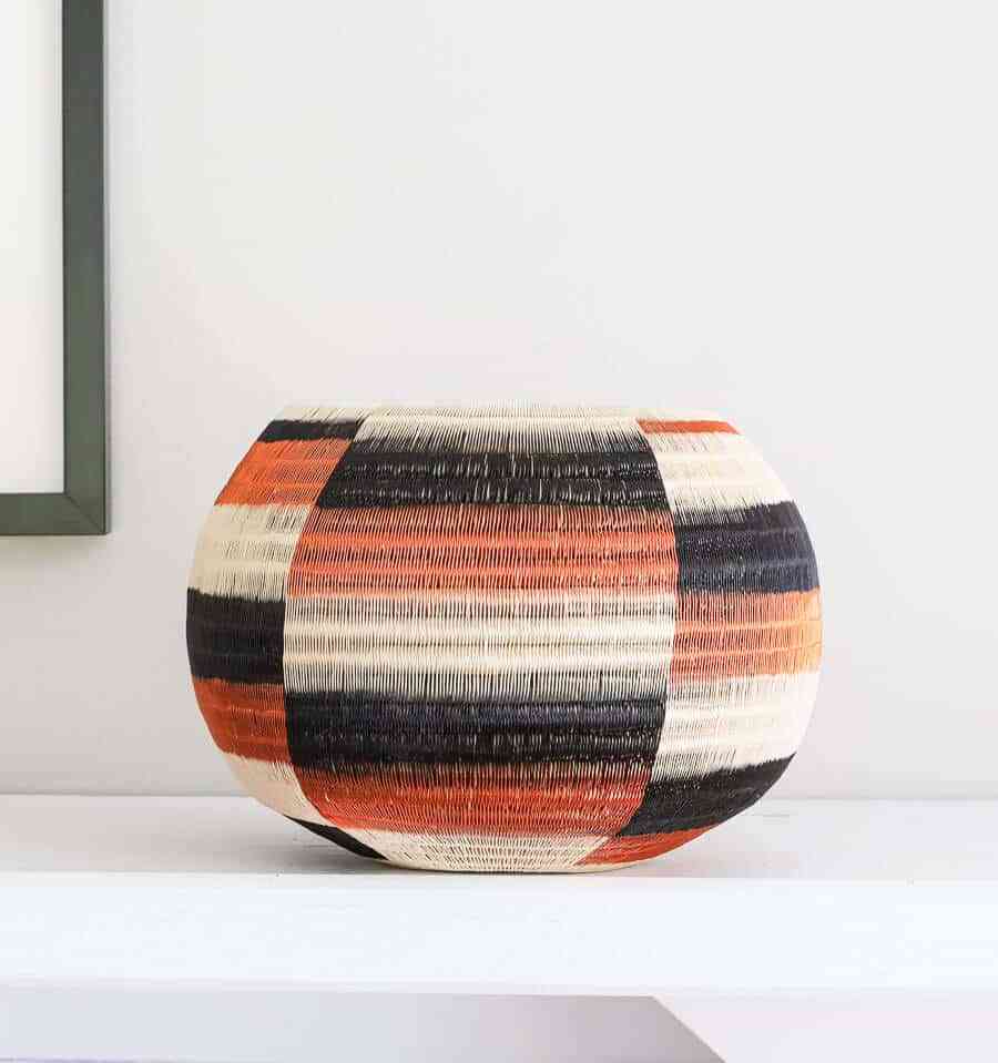 Side angle view of handmade decorative basket showing dimensional wide steps geometric weave pattern