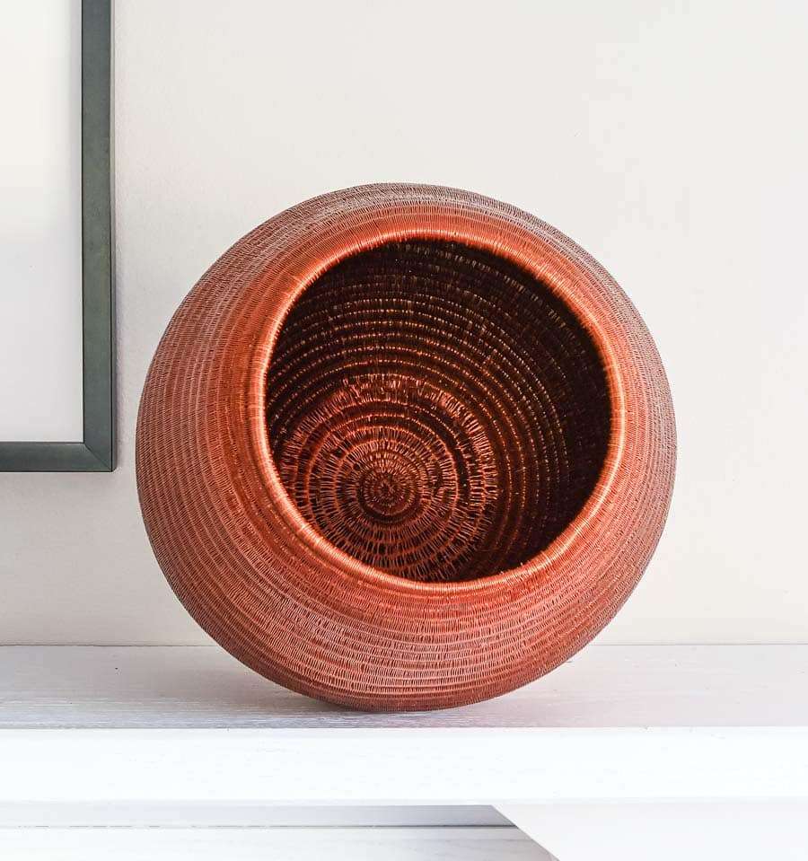 top view of tapered woven basket showing elegant curved silhouette and natural fiber texture