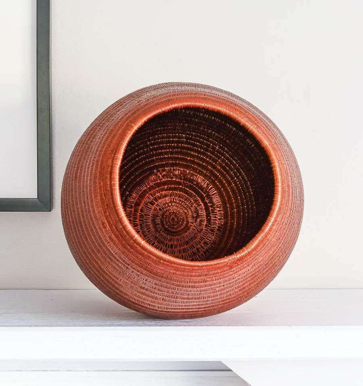 top view of tapered woven basket showing elegant curved silhouette and natural fiber texture