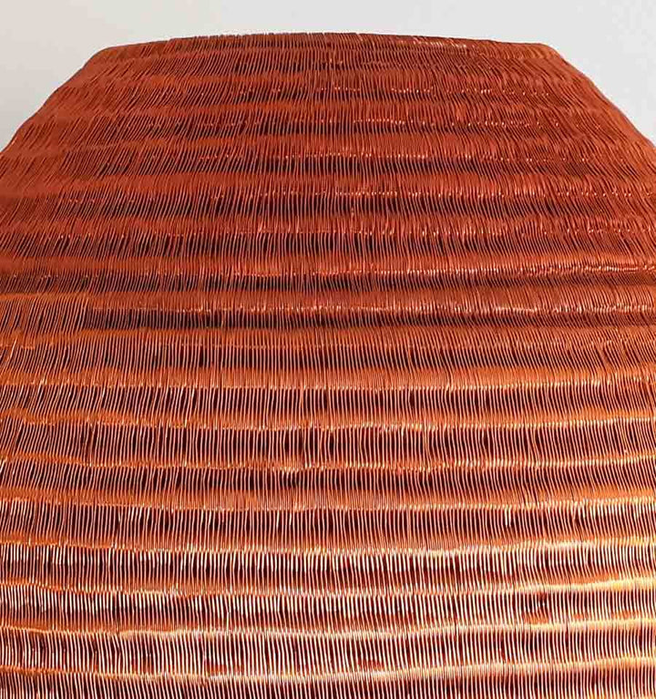 Close-up of copper-toned basket weave showing tight coiling and natural fiber craftsmanship