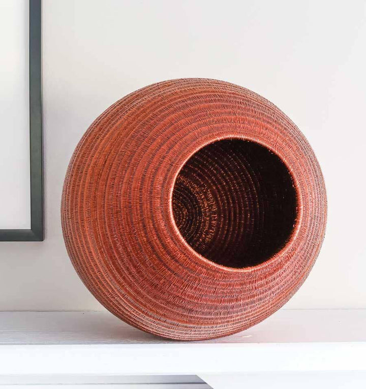 Side view of large decorative copper vessel basket showing sculptural vessel form