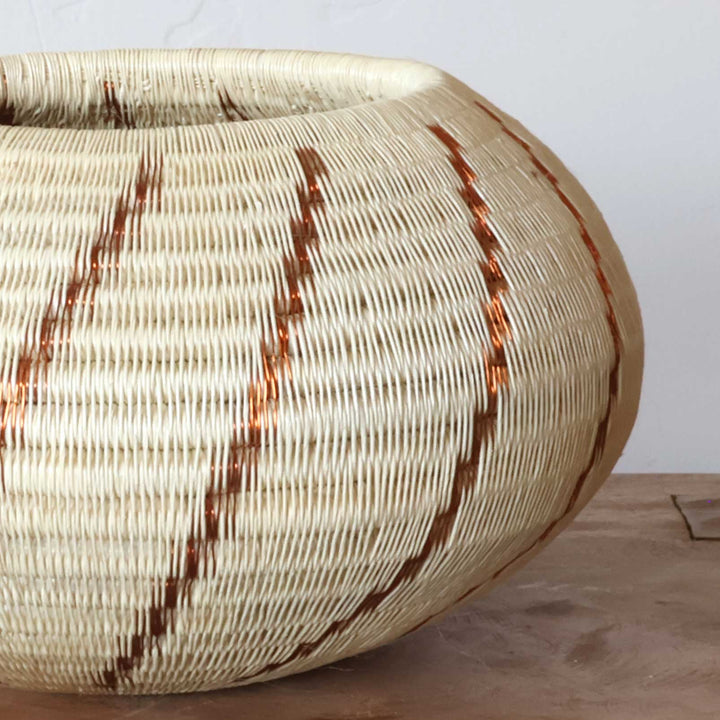 Close-up copper swirl weaving pattern detail natural palm fiber traditional indigenous technique
