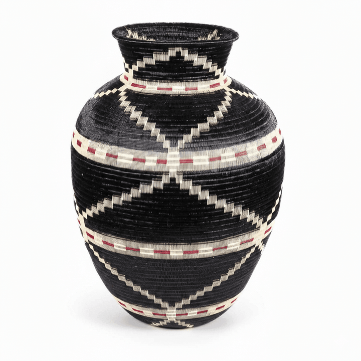 Side view of handwoven Colombian basket showing circular geometric pattern in natural palm fiber dyes
