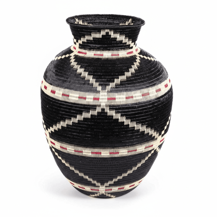 Side view of handwoven Colombian basket showing circular geometric pattern in natural palm fiber dyes