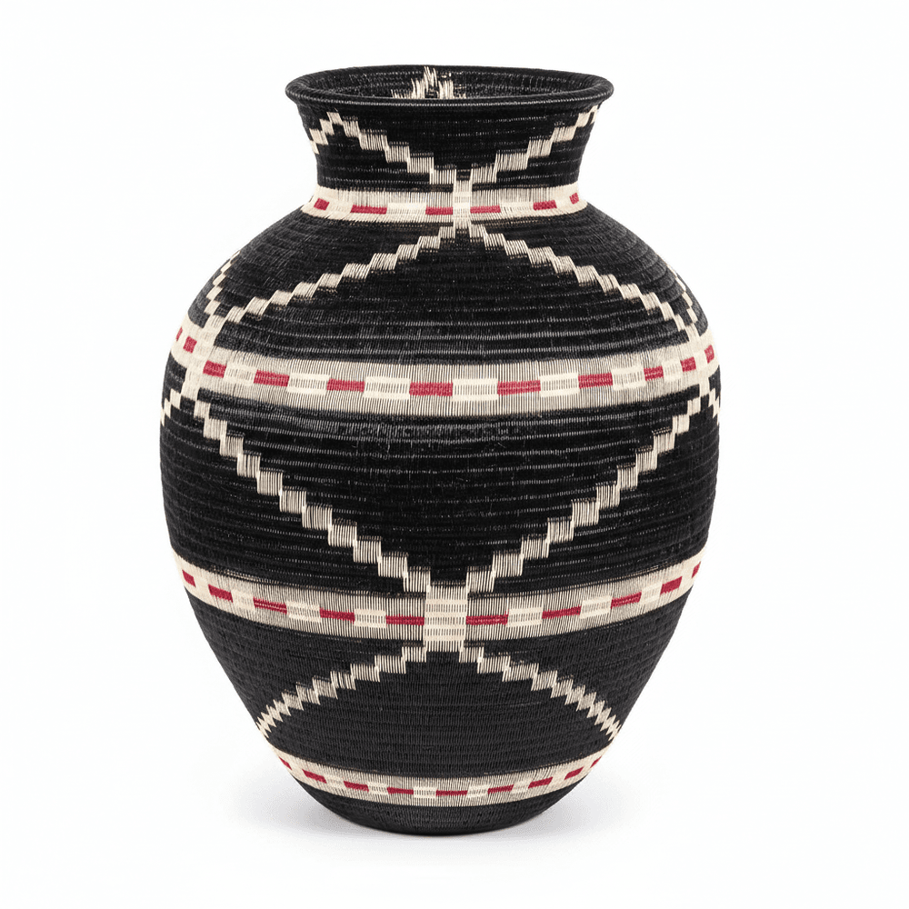 Side view of handwoven Colombian basket showing circular geometric pattern in natural palm fiber dyes