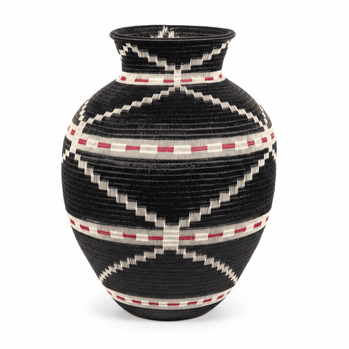 Side view of handwoven Colombian basket showing circular geometric pattern in natural palm fiber dyes